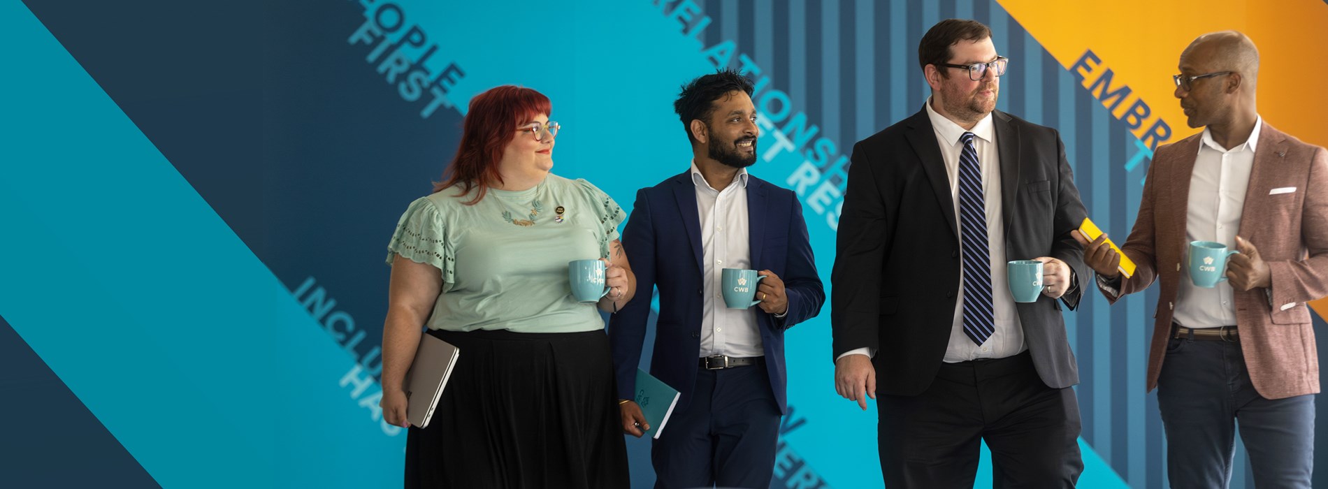 CWB employees standing with branded mugs waiting to meet their clients